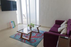 a living room with a purple couch and a coffee table at An amazing stay in Progreso, close to everything in Progreso