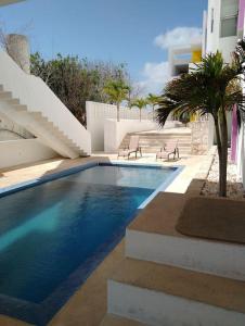 a swimming pool with two chairs next to a building at An amazing stay in Progreso, close to everything in Progreso