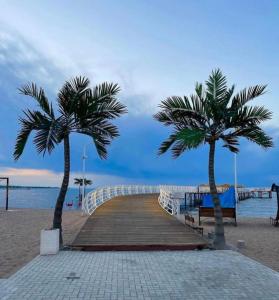 dos palmeras en un paseo marítimo en la playa en Palm Beach Issyk Kul VIP30/3, en Chok-Tal