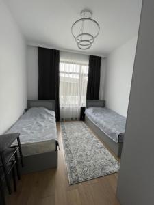 1 dormitorio con 2 camas, mesa y lámpara de araña en Palm Beach Issyk Kul VIP30/3, en Chok-Tal
