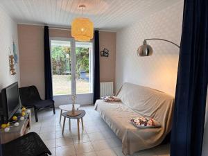ein Wohnzimmer mit Sofa und Fernseher in der Unterkunft 100 M DE LA PLAGE 100 DU BOURG DES MOUTIERS EN RETZ in Les Moutiers