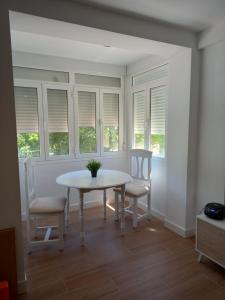 a dining room with a table and chairs and windows at Apartamento_Santa Isabel in Utrera