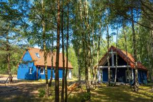 una casa azul en medio de árboles en Stilo Domki en Sasino
