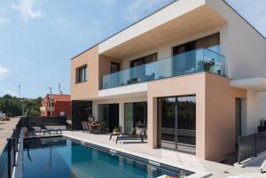 ein Haus mit Pool davor in der Unterkunft Villa Barbara in Pakoštane