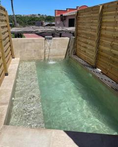 una piccola piscina d'acqua con recinzione in legno di Molí gran a Santa Eulalia de Ronsaná