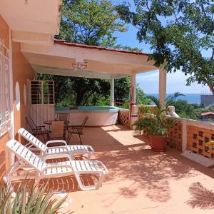 une terrasse avec des chaises et une baignoire dans une maison dans l'établissement Casa Blanca Zipolite, Dream House, à Zipolite