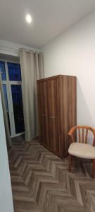 a room with a wooden cabinet and a chair at 3 Maja 33 in Przemyśl