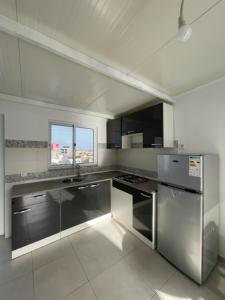 een keuken met roestvrijstalen apparatuur en een raam bij Apartamento in Praia