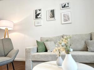 ein Wohnzimmer mit einem Sofa und einem Stuhl in der Unterkunft MyStay: Zentral I Design I Prime I Gäste WC in Heidelberg