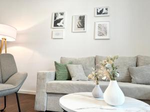 uma sala de estar com um sofá e dois vasos sobre uma mesa em MyStay: Zentral I Design I Prime I Gäste WC em Heidelberg