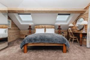 a bedroom with a bed and a desk at Owl Barn in Oxford