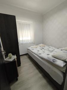 Un dormitorio con una cama grande y una ventana en Stella Apartman, en Hajdúszoboszló