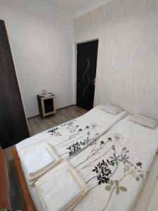 a bedroom with a bed with a black and white comforter at Stella Apartman in Hajdúszoboszló