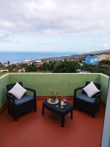 two chairs and a table on a balcony with the ocean at Casa Olini in Breña Alta