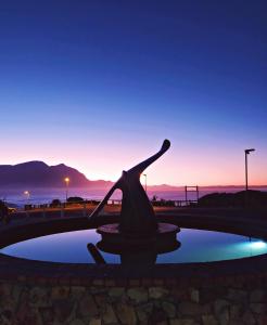a statue of a bird sitting in a pool of water at Apartment at Hermanus Waterfront in Hermanus