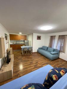 uma sala de estar com um sofá azul e uma cozinha em Apartmani Rozi em Umag