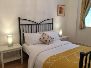 a bedroom with a bed with two tables and two lamps at The Queen Hotel in Olney