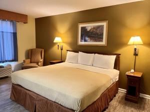 a hotel room with a large bed and a chair at FairBridge Inn Express Mount Vernon in Mount Vernon