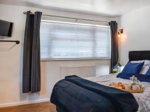 a bedroom with a bed and a large window at The Annexe The Roost in Godshill