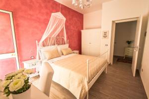 a bedroom with a white bed with a canopy at Venustas in Lampedusa