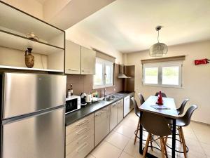 a kitchen with a stainless steel refrigerator and a table at Villa Papagiorgio Luxury and Harmony in Gennadi