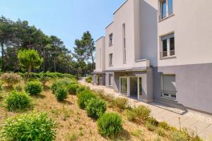 ein weißes Gebäude mit Pflanzen davor in der Unterkunft Apartment Nora in Mali Lošinj