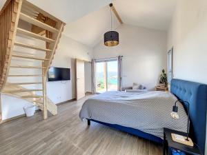 Un dormitorio con una cama azul y una escalera en Gîte Le Panoramique en Bilieu