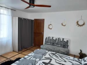 1 dormitorio con 1 cama y ventilador de techo en maison d'hôtes labastide en Villenave