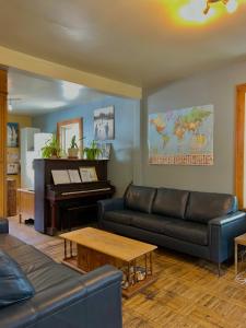 a living room with a couch and a piano at Auberge Internationale de Rivière-du-Loup in Rivière-du-Loup