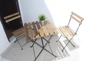 twee houten stoelen en een plant naast een tafel bij El rinconcito in Fuenteheridos