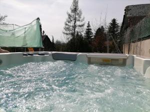 a bath tub filled with water in a yard at Chalupa u Manišov in Laskár