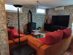 uma sala de estar com um sofá e uma televisão em La casa de Gloria em Cúllar-Vega