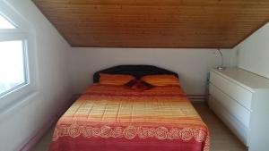 Posto letto in una piccola camera con soffitto in legno. di Apartment Sunset a Portoroz