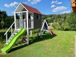 um parque infantil com escorrega e uma casa de brincar em Borówkowy Jar em Ropienka