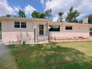 une maison blanche avec une cour d'herbe devant elle dans l'établissement Sweet home Alabama, à Huntsville