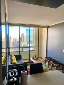 een woonkamer met een bank en een groot raam bij R&B Apartments in Santiago