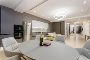 a white dining room with a white table and chairs at Luxury apartment close to the city centre in Chişinău