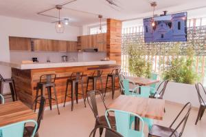 a restaurant with wooden tables and chairs and a kitchen at Hostal Las Guaduas in Santa Marta