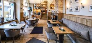 ein Restaurant mit Tischen und Stühlen in einem Zimmer in der Unterkunft Pension "Am Nico" in Wernigerode