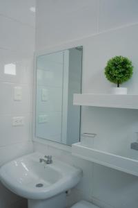 a white bathroom with a sink and a mirror at Casa Llanos de Costa y Mar in San Clemente