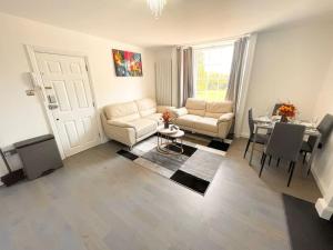 a living room with a couch and a table at Entire Apartment hosted by Pius in Redhill