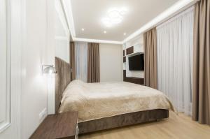 a bedroom with a bed and a television in it at Luxury apartment close to the city centre in Chişinău