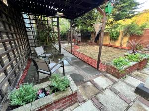 eine Terrasse mit zwei Stühlen und einigen Pflanzen in der Unterkunft Beautiful Room for ONE Person - free Netflix, Amazon Prime & Disney plus in Bromley