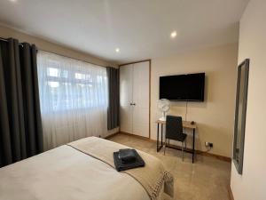 a bedroom with a bed and a flat screen tv at Beautiful Room for ONE Person - free Netflix, Amazon Prime & Disney plus in Bromley
