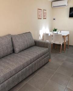 uma sala de estar com um sofá e uma mesa com cadeiras em *Viejo Refugio* em Tandil