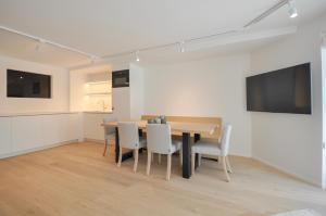 a kitchen and dining room with a table and chairs at Premium modern flat at Zoute Beach 2 bicylcles included in Knokke-Heist