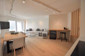 a living room with a table and a living room with a couch at Premium modern flat at Zoute Beach 2 bicylcles included in Knokke-Heist