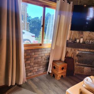 卡曼杜卡亞的住宿－Chalé Colorado Vibe，客厅设有窗户和电视