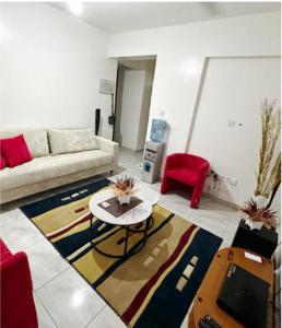 uma sala de estar com um sofá e uma mesa em DelYves Homes em Mombasa