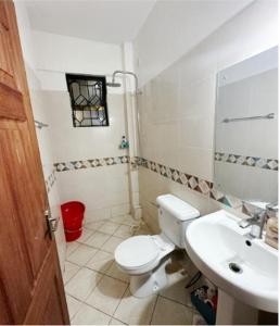 uma casa de banho com um WC e um lavatório em DelYves Homes em Mombasa